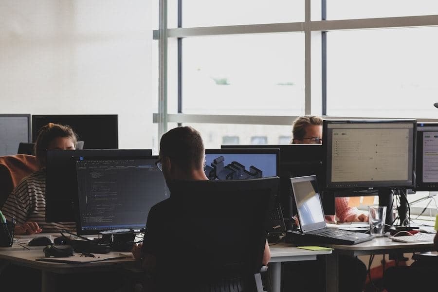 Team working at desks of monitors in a bright open-plan office