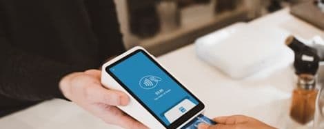 Technician taking a contactless card payment on a handheld terminal