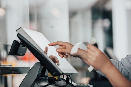 Shop assistant tapping a countertop touchscreen register