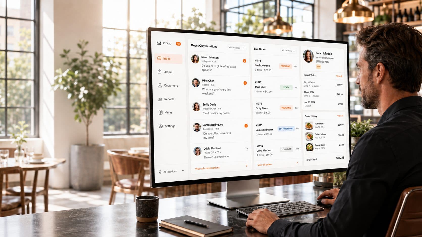 A restaurant manager at a desk reviewing the Vertex unified guest inbox on a desktop monitor: a Guest Conversations pane, a Live Orders pane and a guest profile panel with recent visits and order history, all side by side on one screen.